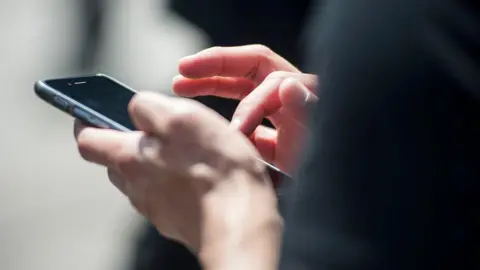 Getty Images A woman using her mobile phone.